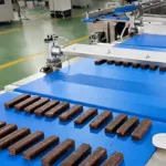 Ligne automatique d'alimentation et de disposition de barres de fromage blanc enrobées de chocolat