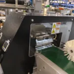 Ligne automatique d'alimentation et de disposition de barres de fromage blanc enrobées de chocolat
