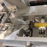 Ligne automatique d'alimentation et de disposition de barres de fromage blanc enrobées de chocolat